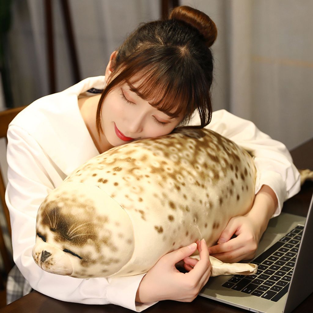 Seal plush pillow used for hugging and relaxing while sitting at a table