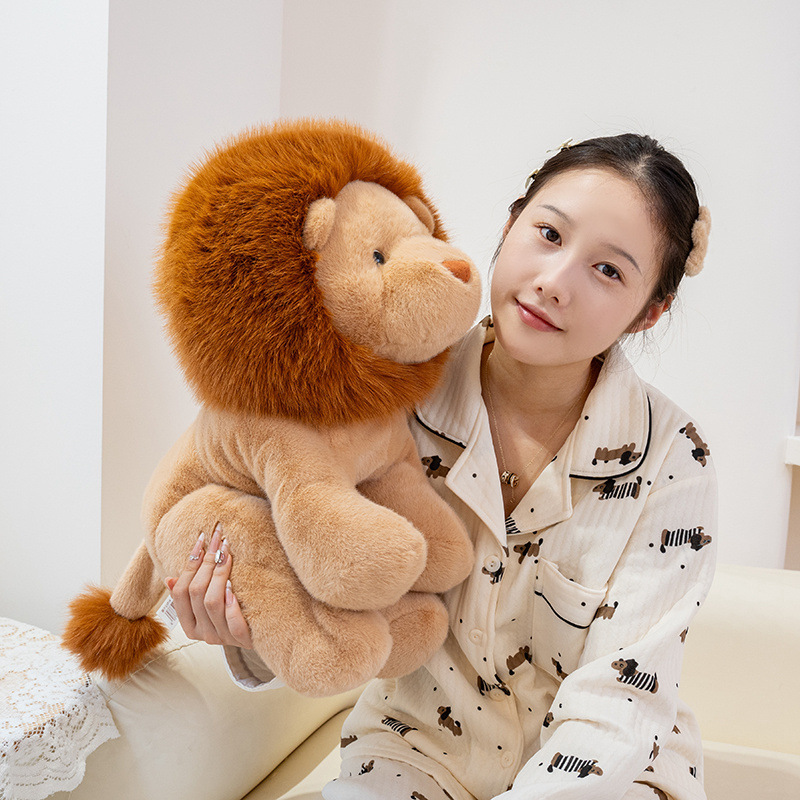 Lion plush toy held in arms, showing soft texture and cuddly size for cozy comfort