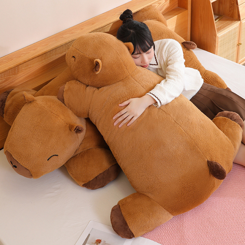 Capybara plush cushion used as a soft hugging pillow on bed