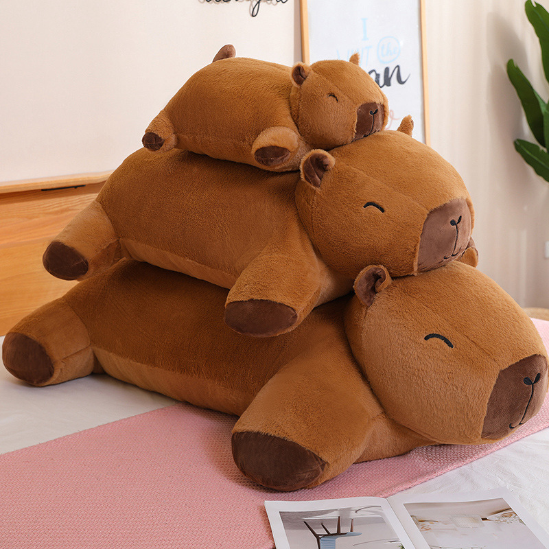 Capybara plush cushion in three sizes stacked on bed for cozy lounging and relaxing