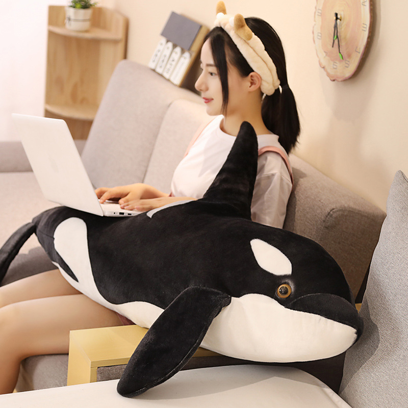 Orca killer whale long plush pillow used as a cozy lap pillow on sofa for relaxing and home decor