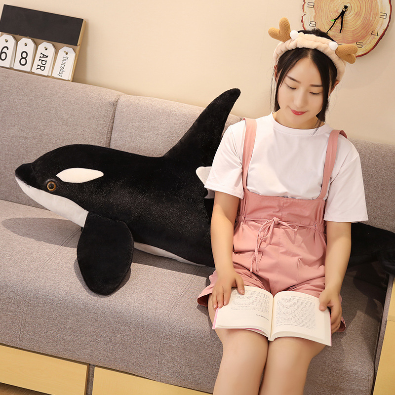 Orca killer whale long plush pillow placed on sofa as a soft companion for relaxing and reading