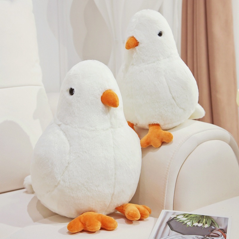 White pigeon plush toys on sofa creating a soft and cozy home decor atmosphere