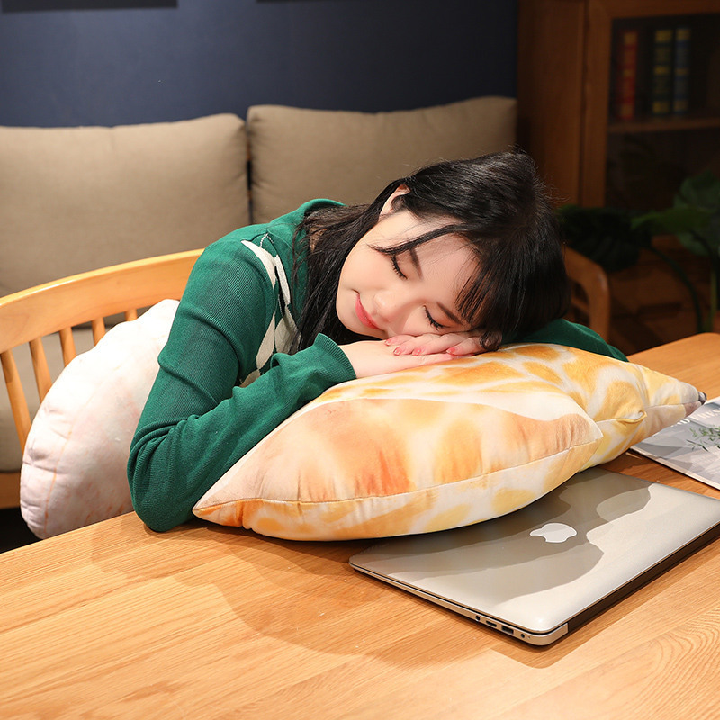 Realistic conch shell plush pillow used for resting and napping on a desk, soft and comfortable ocean-inspired pillow for home or office relaxation