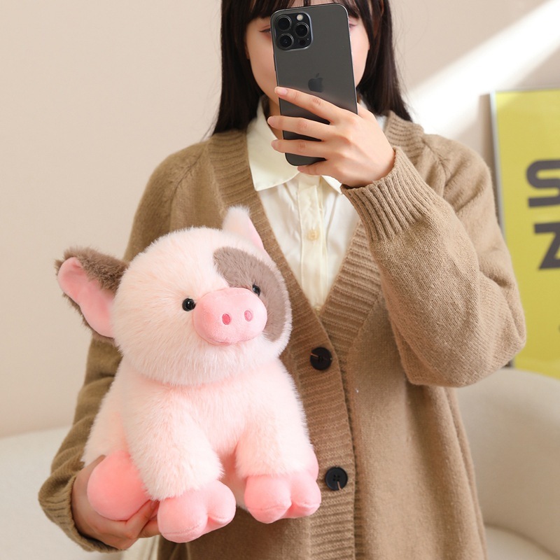 Cute mini pig plush toy displayed in hand, featuring soft plush fabric, rounded shape, and pastel pink tones, suitable for cozy home decor, gifting, or comforting hugs