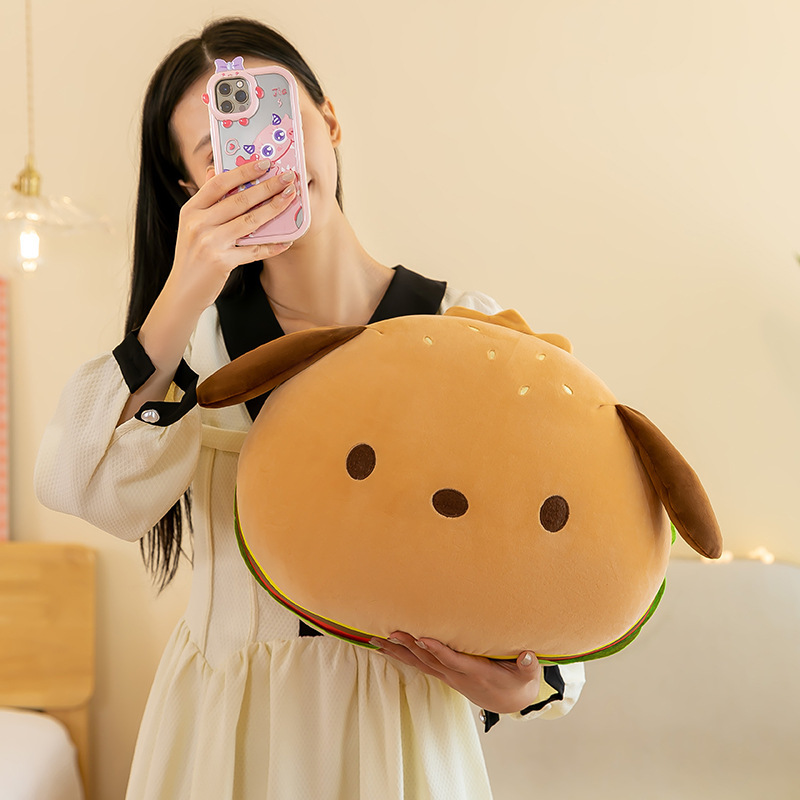 Burger dog plush pillow held in hands, soft round cushion for hugging and home decor, cozy lifestyle scene