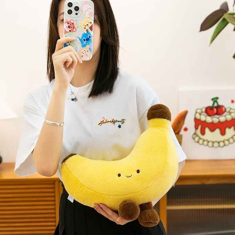 Banana plush toy with legs held in arms, soft yellow banana plush for hugging, cute design for cozy home decor and relaxation
