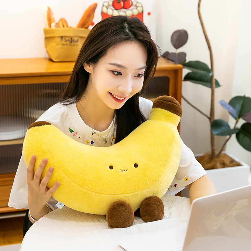Banana plush toy with legs used as a cuddle pillow on a table, cozy and playful atmosphere for everyday relaxation
