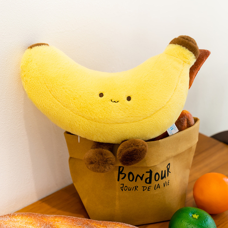Banana plush toy with legs displayed in a paper bag on a wooden table, cute soft banana plush used as home decor accent