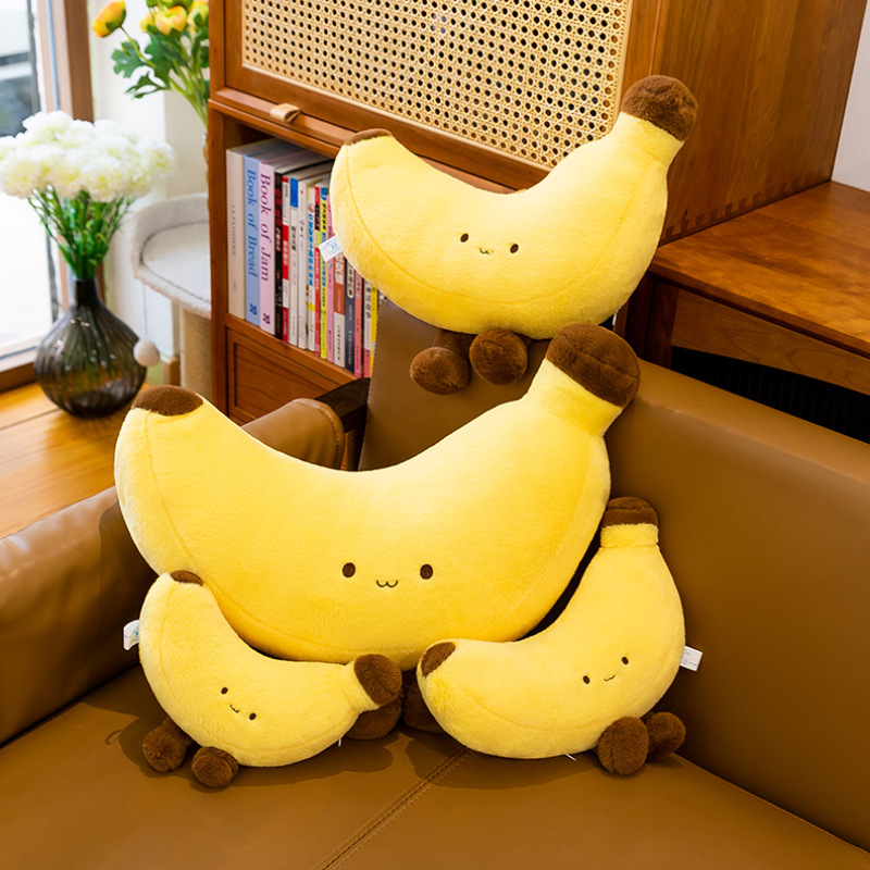Banana plush toy with legs in multiple sizes displayed on a sofa, soft yellow banana plush cushions arranged together for cozy home decor and playful lounging atmosphere