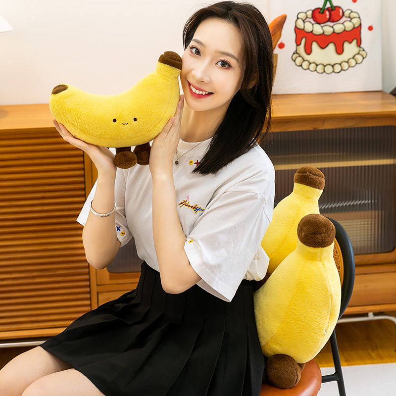 Banana plush toy with legs used as a cozy cuddle companion in a warm indoor setting, soft and cute design for relaxing and decorative use