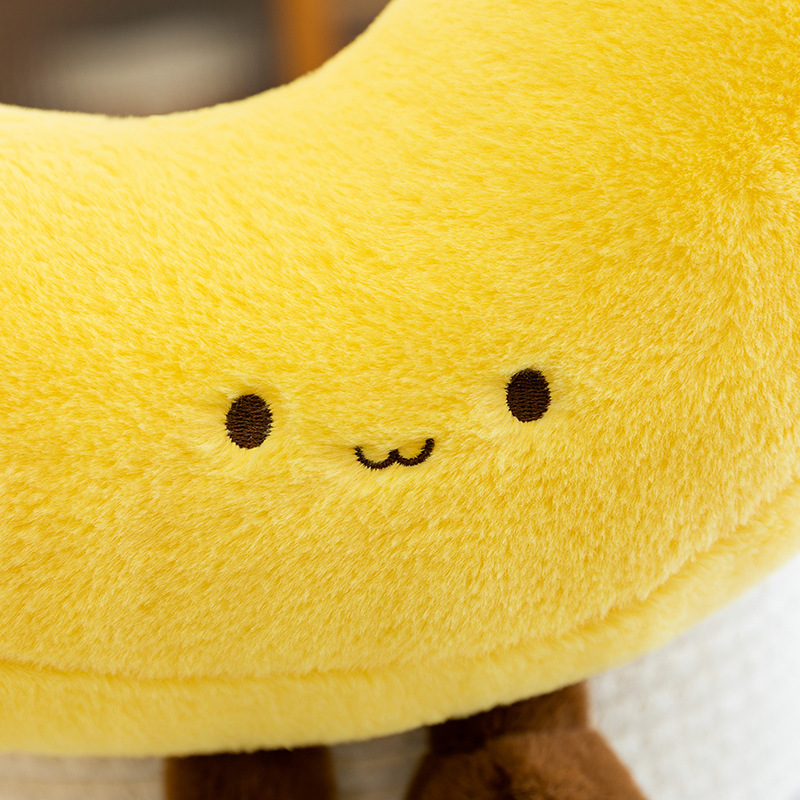 Cute embroidered face detail of banana plush toy in soft plush fabric