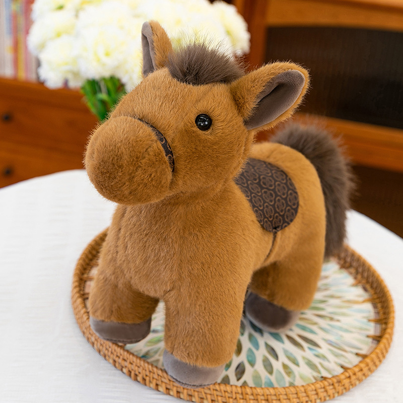 Realistic pony plush toy with saddle in brown color, soft stuffed horse placed on a woven tray in a warm indoor setting, highlighting fluffy texture and balanced shape for cuddling or decorative display