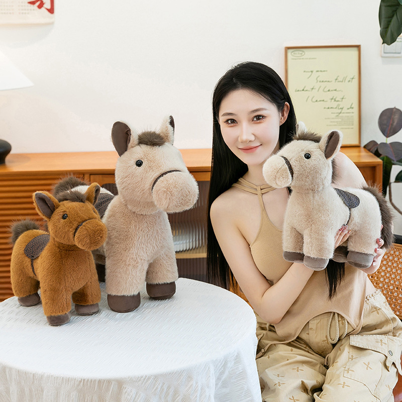Realistic pony plush toys in multiple sizes displayed on a table, showing detailed saddle design and soft plush texture, ideal for home decor, gifting, and cozy room styling