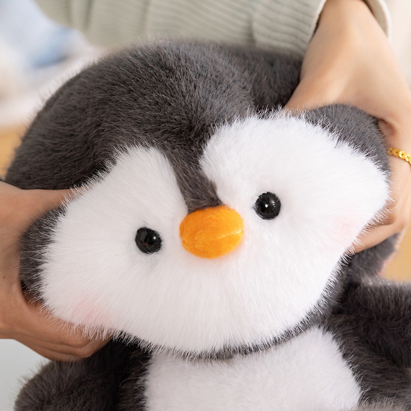 Coco penguin plush toy shown being gently squeezed, demonstrating its soft, fluffy filling and comforting hug feel, perfect for relaxation, stress relief, and cozy home moments