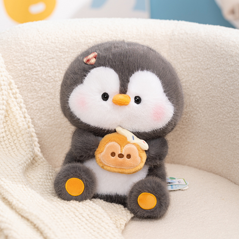 Coco penguin plush toy holding dessert, soft and round penguin stuffed toy on a sofa, cute plush design for everyday comfort, gifting, and home decoration
