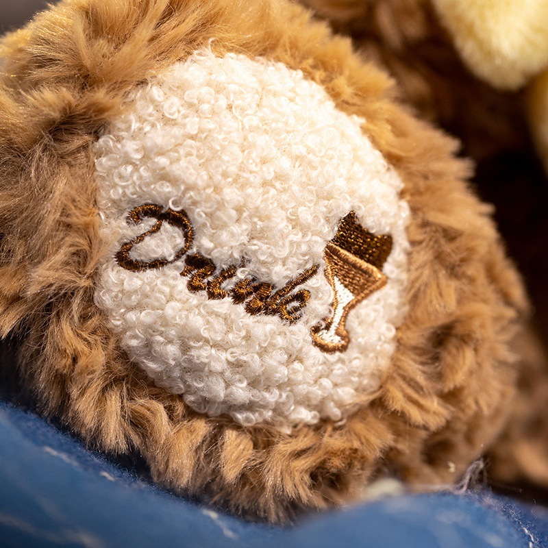 Close-up of milk tea bear plush toy paw with embroidered drink icon, showing soft plush texture and detailed stitching
