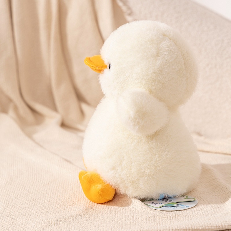 White duck plush toy side view resting on a sofa, featuring a rounded body, soft plush texture and calm cozy atmosphere, ideal for home decor and relaxing moments