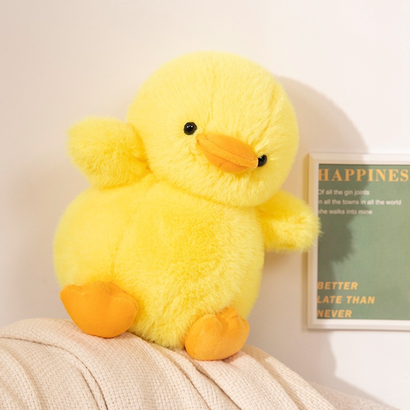 Yellow duck plush toy resting on a sofa backrest, featuring a soft fluffy texture and rounded shape, creating a cozy and cheerful home decor atmosphere