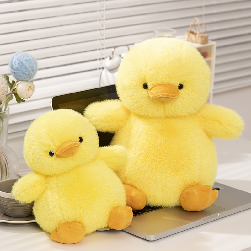 Yellow duck plush toys with a soft fluffy texture placed on a desk, creating a cozy and cheerful workspace decoration