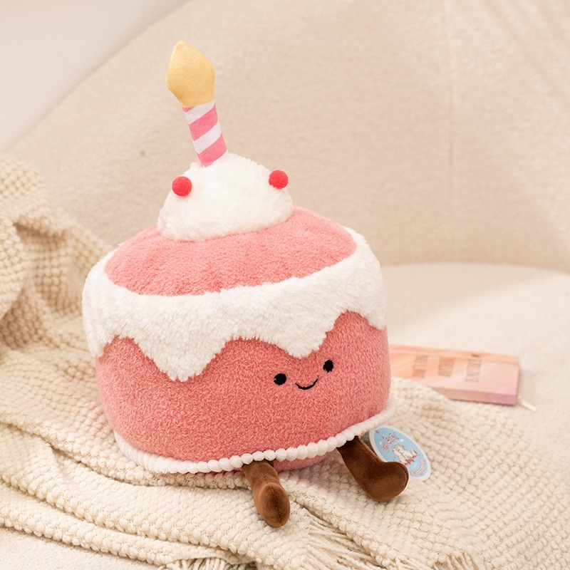 Pink memory dessert cake plush toy displayed on a sofa, featuring a soft fluffy texture and a cute cake-inspired design