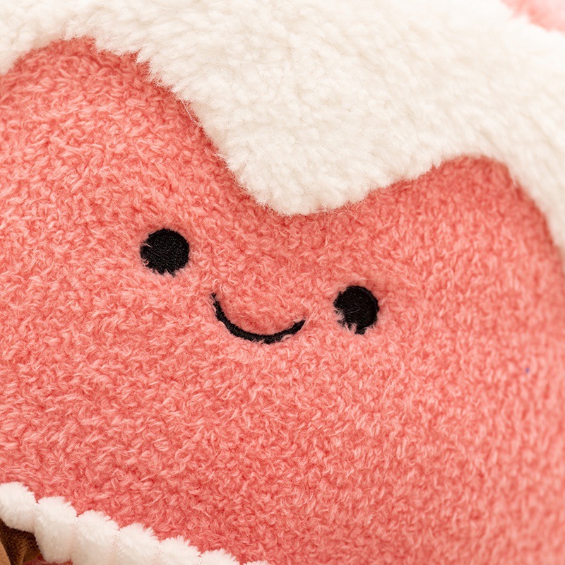 Close-up of pink memory dessert cake plush toy showing soft plush texture and embroidered smiling face