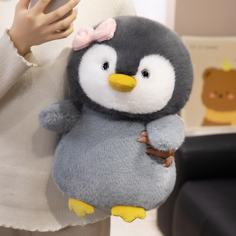 Bow penguin plush toy held for hugging with soft plush fabric