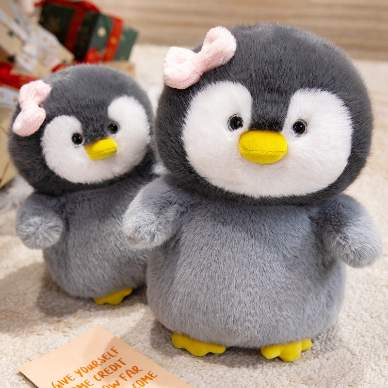 Bow penguin plush toys displayed together with fluffy texture