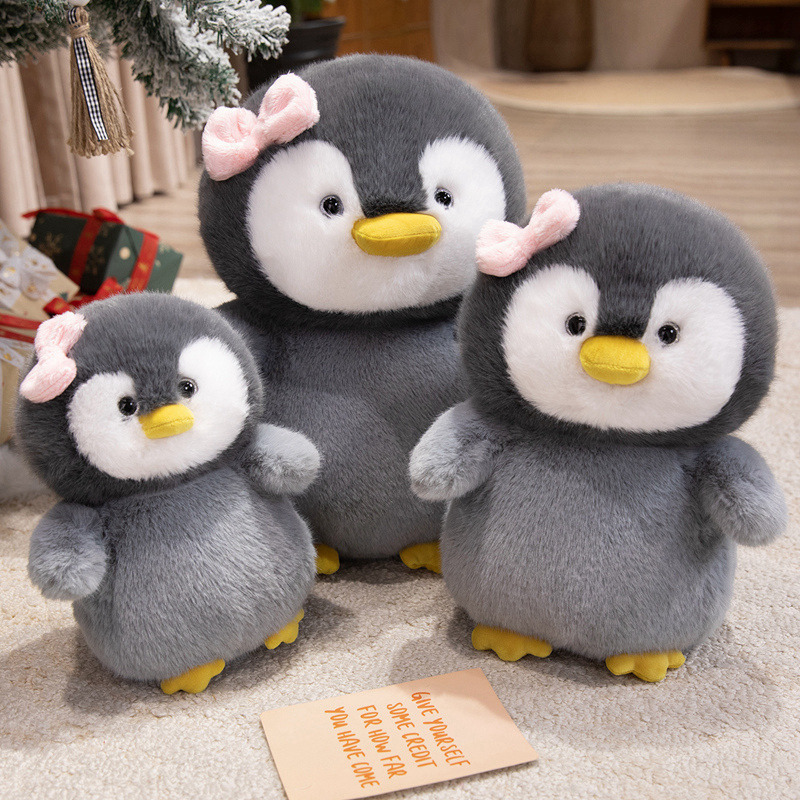 Bow penguin plush toys displayed together with soft fluffy design