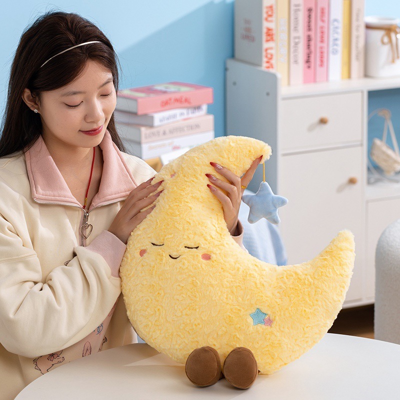 Healing moon plush pillow held for hugging, soft plush cushion with calming design, cozy companion for relaxing at home