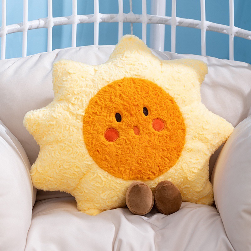 Sun plush pillow displayed on a cozy chair, featuring a soft star-shaped design with a smiling face, fluffy texture, and warm yellow tones, ideal for relaxing corners and home decor