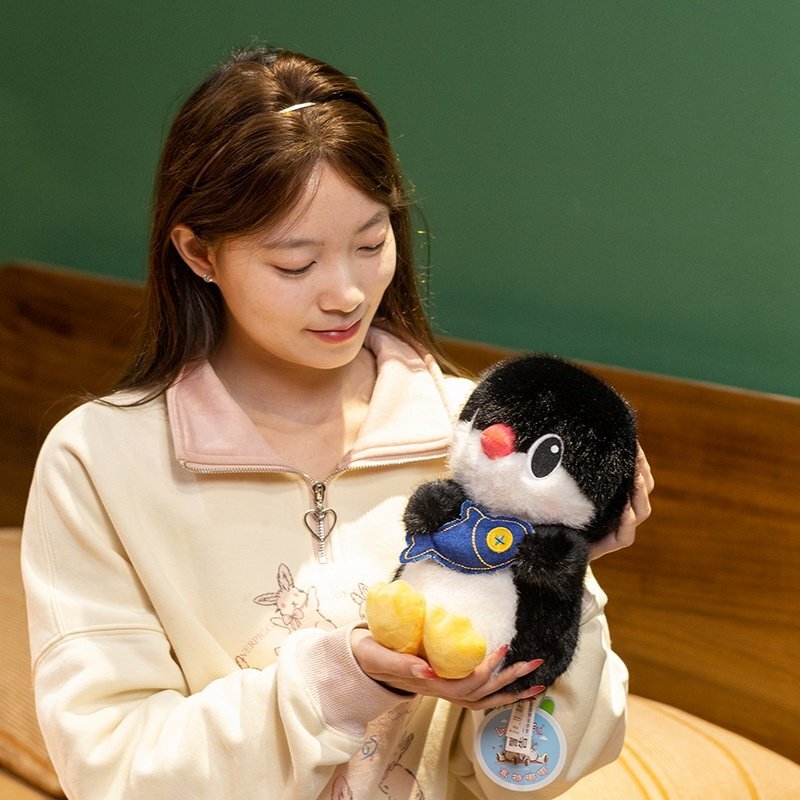 Cute penguin plush toy used as a comforting companion, soft stuffed animal ideal for cuddling and cozy moments at home
