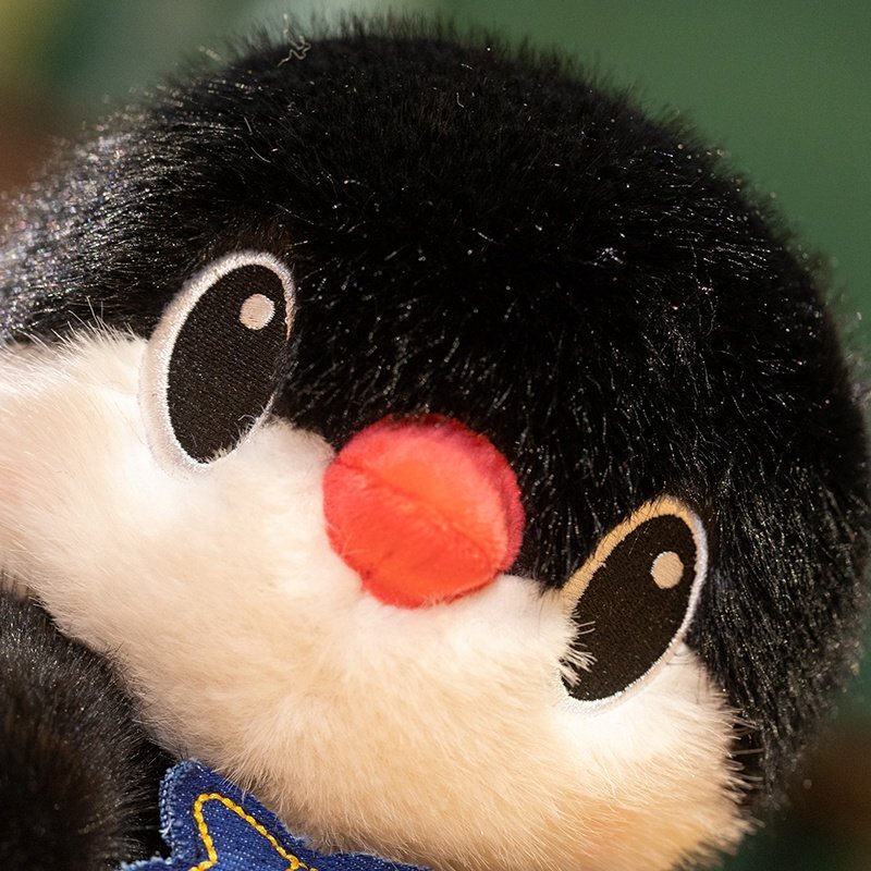 Penguin plush toy close up showing soft fluffy texture and embroidered eyes and beak