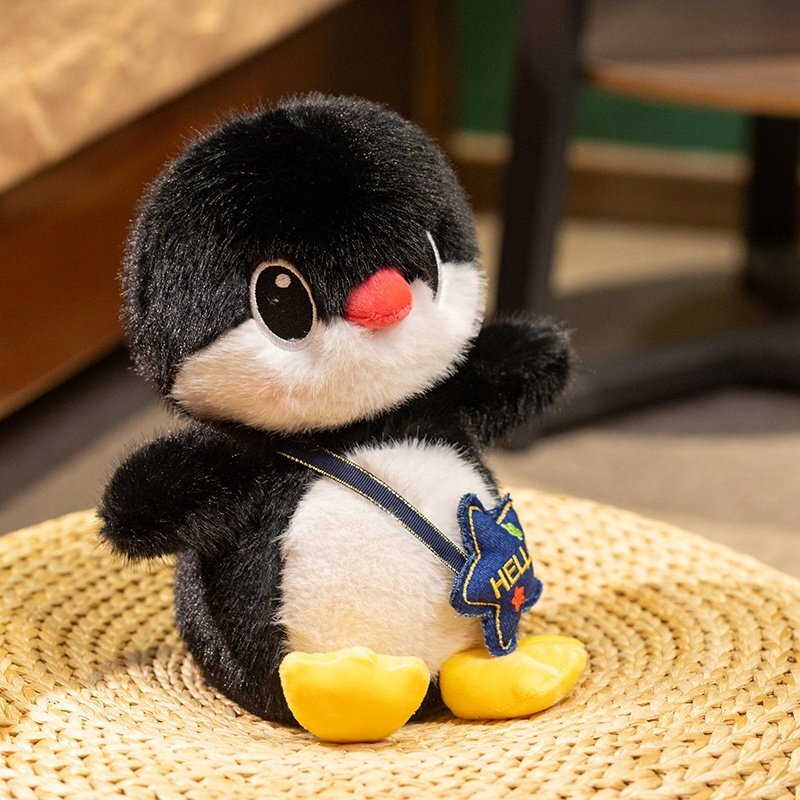Penguin plush toy with star backpack sitting on a woven mat, showing soft texture and cozy decorative style