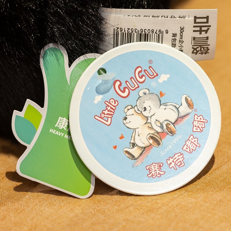Penguin plush toy product tag detail showing size and care information