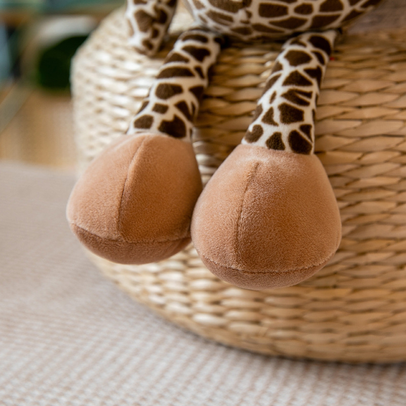 Close-up of giraffe plush toy legs showing soft plush fabric texture and padded feet detail