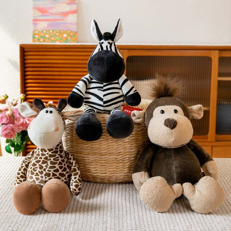 Jungle animal plush toys featuring zebra, giraffe and monkey arranged in a warm indoor setting
