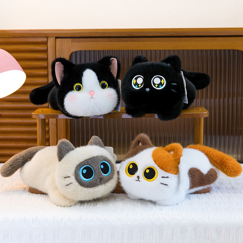 Soft lying cat plush toys displayed on a shelf and bed, featuring black, siamese, calico, and cow cat designs with a fluffy texture and relaxed pose, creating a cozy and cute home atmosphere