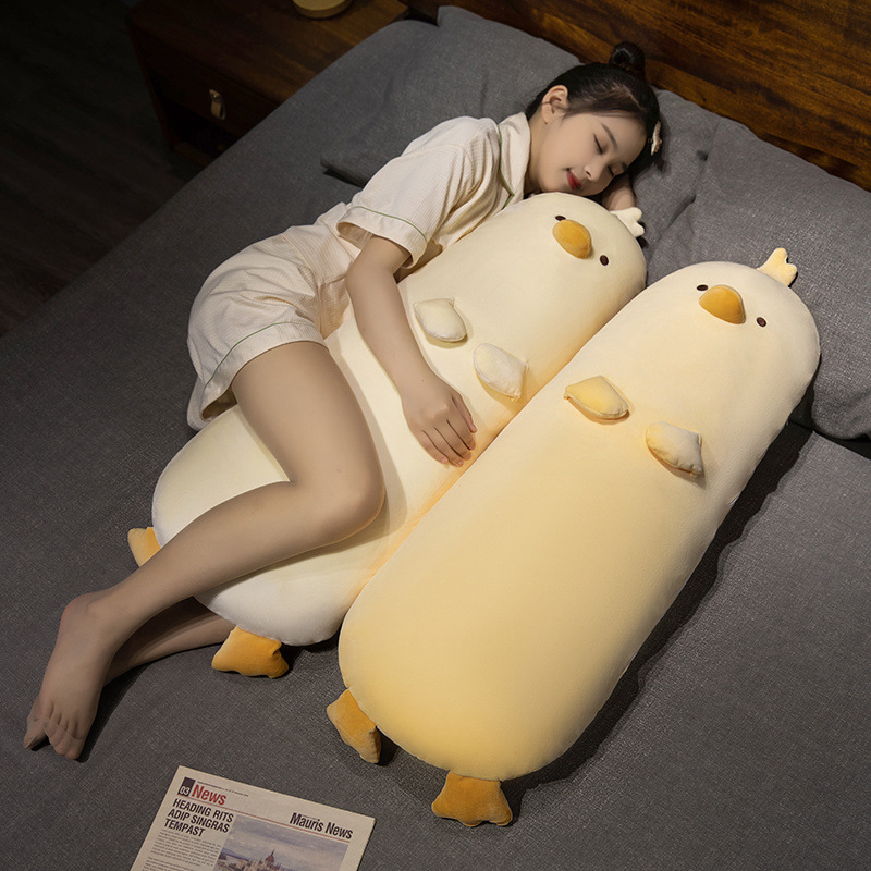 Milk chick plush pillows in milky white and milky yellow placed on bed, extra long chicken body pillow design for hugging and sleeping, soft plush texture, warm and relaxing home decor style
