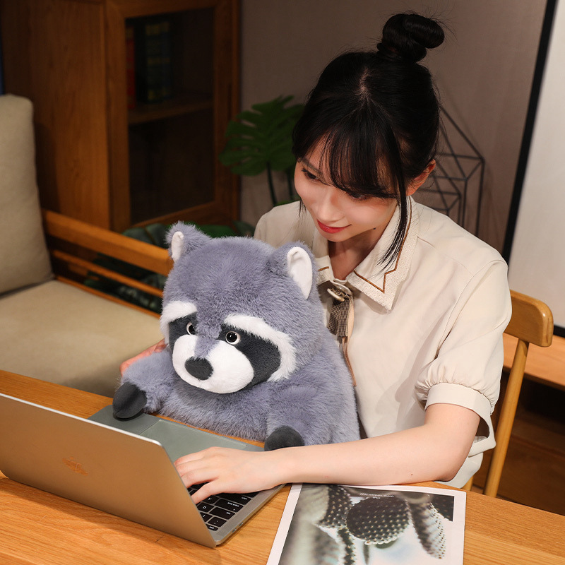 Chubby raccoon plush toy placed on a desk as a cozy companion, featuring soft plush fabric, rounded body design, and comforting presence for work, study, or relaxing moments