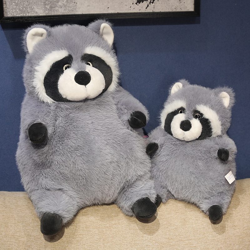 Chubby raccoon plush toys in two sizes displayed on a sofa, featuring round shape, fluffy plush fabric, and a cozy, comforting look for home decoration and relaxation