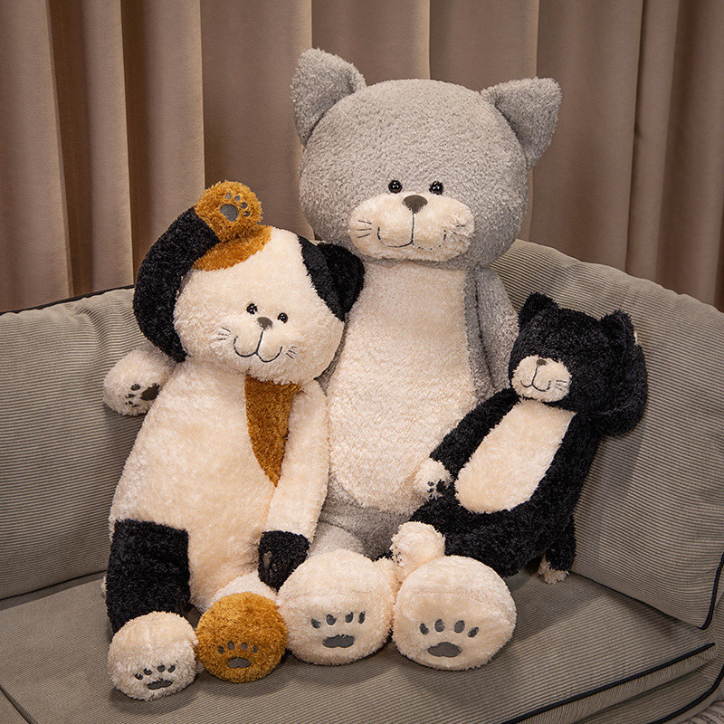 Jimmy cat plush toys in gray black and calico colors sitting on a sofa, soft stuffed cat design with fluffy texture, cozy home decor and relaxing cuddle companion