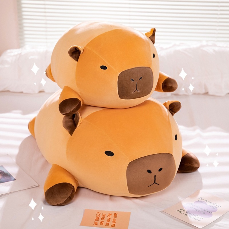 Stacked lying capybara plush pillows on bed creating a cute and cozy atmosphere for home decor and relaxation