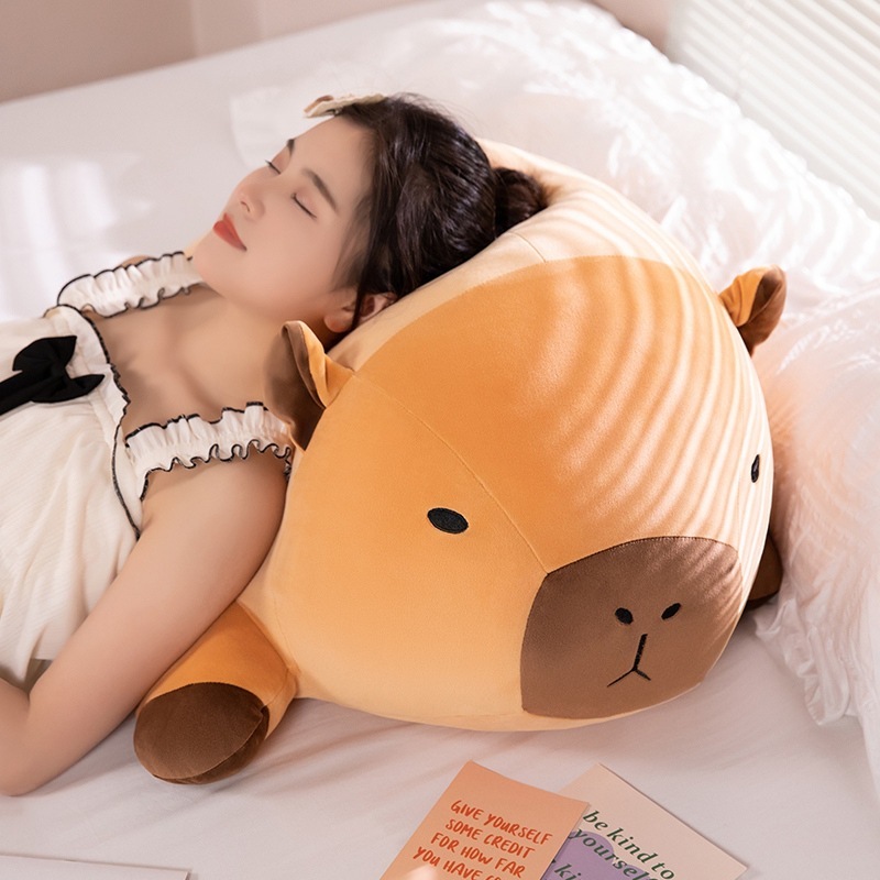 Capybara plush pillow used as a soft body pillow for sleeping and relaxing on a bed