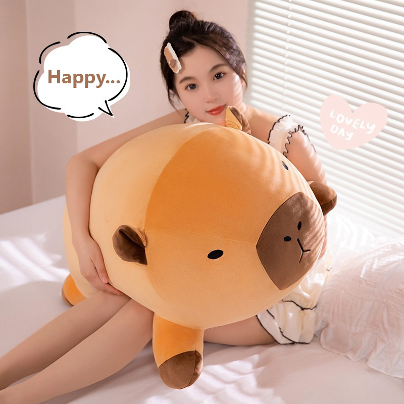 Capybara plush pillow used as a body pillow on a bed, featuring a lying design, soft plush texture, and cozy atmosphere for sleeping or relaxing