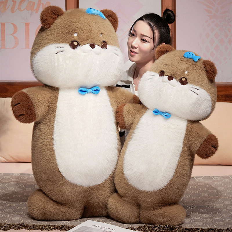 Sea otter plush toy displayed on a bed in a cozy bedroom setting, highlighting soft plush texture, upright sitting design, and comforting presence for hugging and sleep