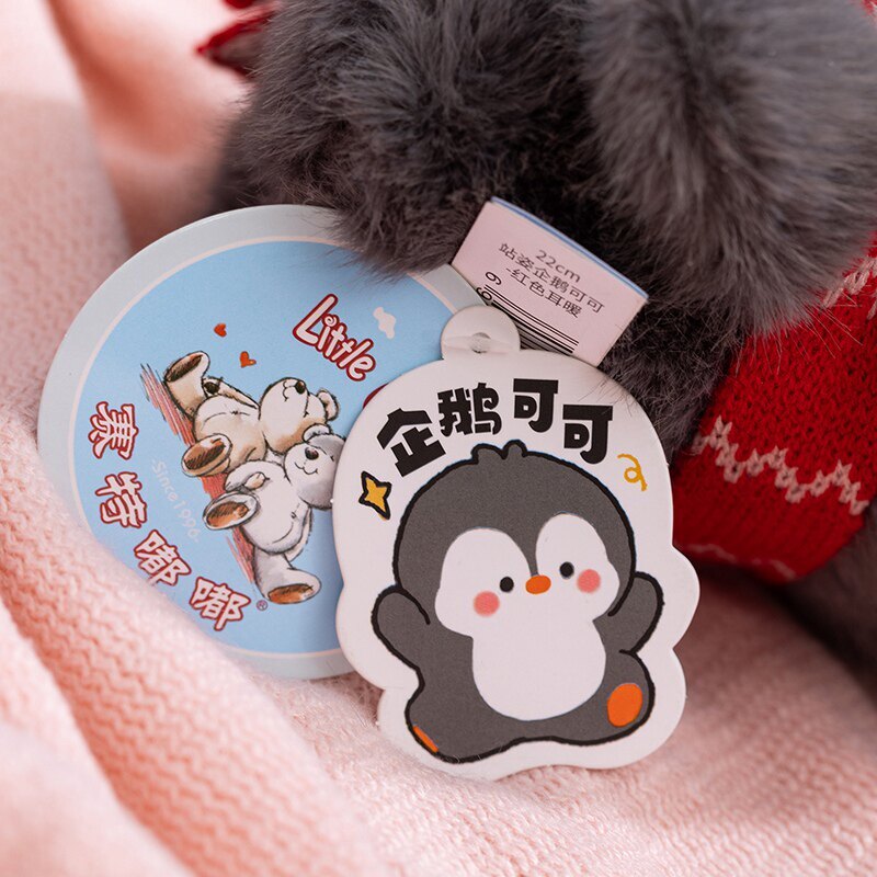 Coco standing penguin plush toy detail showing soft plush fabric, brand tag and character design, cute collectible stuffed animal with fine stitching and cozy feel