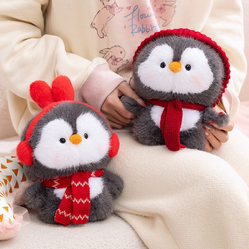 Coco standing penguin plush toys in red ear muffs and red knit hat styles, soft fluffy texture with winter accessories, displayed on a cozy sofa setting, cute plush toys for home decor and gifting