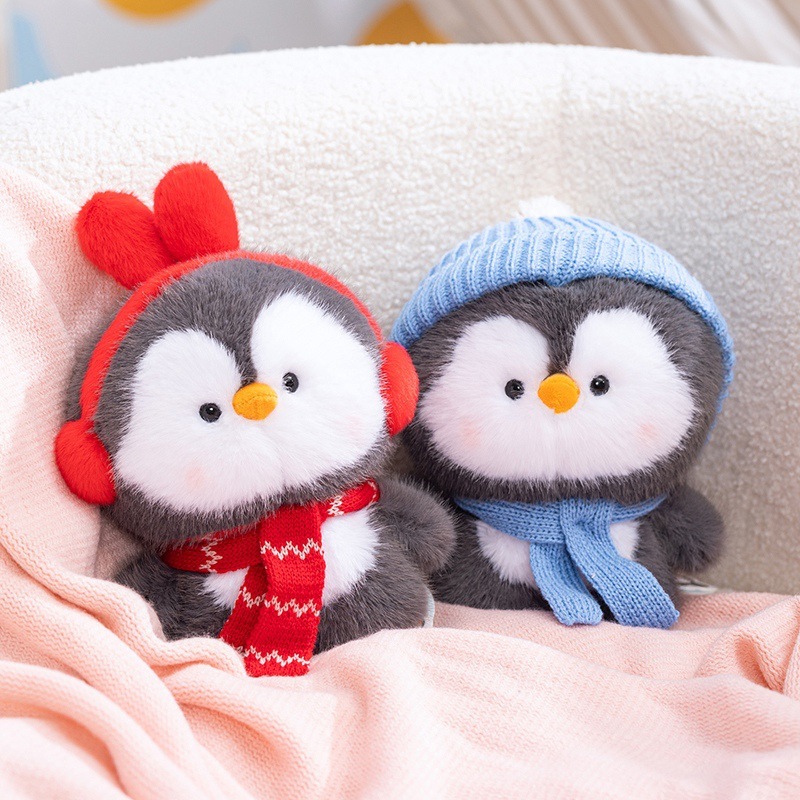 Coco standing penguin plush toys with red ear muffs and blue knit hat, soft stuffed penguin dolls displayed on a cozy sofa, warm and cute home decor plush toys