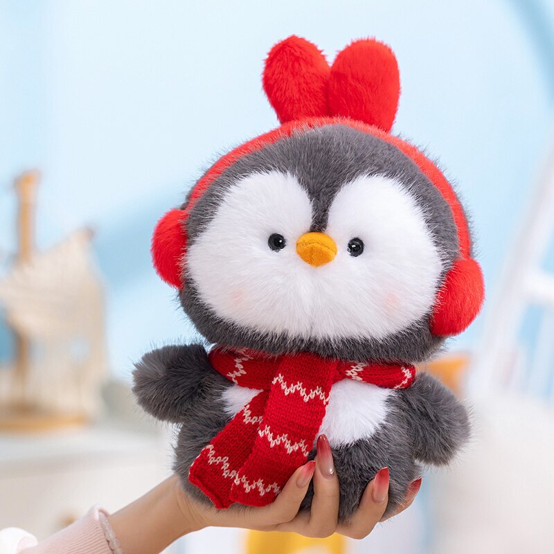 Coco standing penguin plush toy with red ear muffs and scarf, soft fluffy texture, winter style design, cozy handheld plush for decoration, gifting, or everyday comfort
